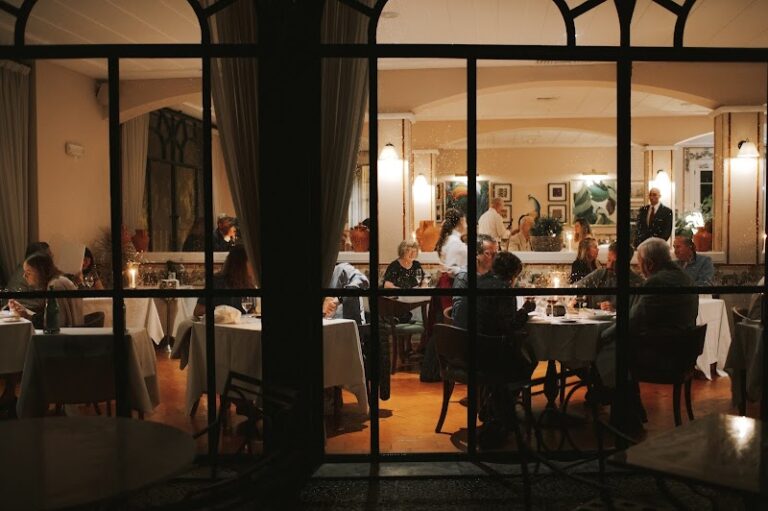 Cozy upscale restaurant interior with diners enjoying candlelit meals.