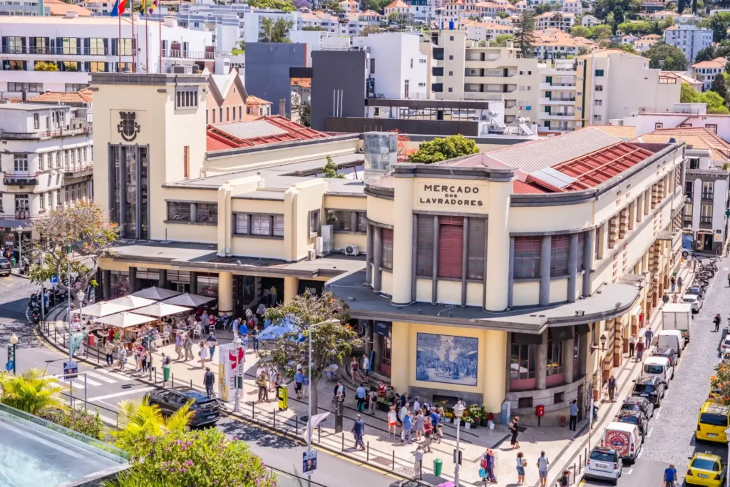Crowded farmers' market building with art deco architecture in city center.